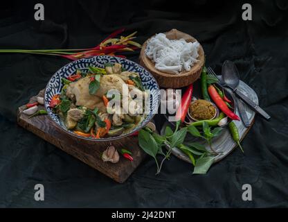 Grünes Kerrys mit Hühnchen und grün-weißen Sorten thailändischer Auberginen (Kaeng Khiao wan) in einer Keramikschale serviert mit thailändischen Reisnudeln (fermentierter Reis f Stockfoto