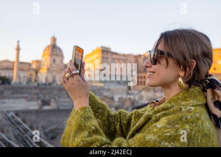 Frau, die das Forum Romanum fotografiert, während sie in Rom unterwegs ist Stockfoto