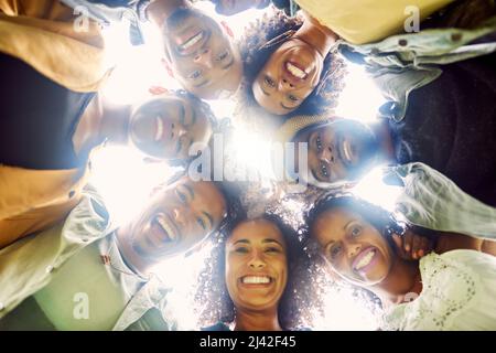 Umgeben Sie sich mit Menschen, die Sie bekommen. Beschnittene Aufnahme einer Gruppe von Freunden, die auf die Kamera herunterschauen. Stockfoto
