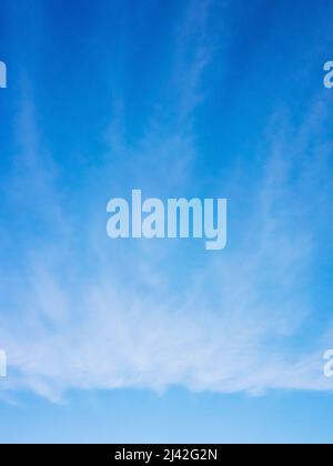 Blauer Himmel mit weichen Wolken, natürlicher vertikaler Fotohintergrund Stockfoto