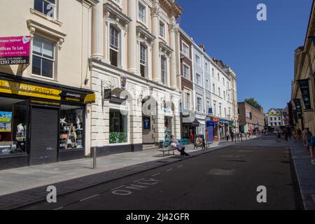 EXETER, Großbritannien – 18. JULI 2021 Käufer in der Queen Street haben Fahrzeuge geschlossen Stockfoto