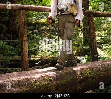 Männlicher Wanderer im Pazifischen Nordwesten über eine handgemachte Holzbrücke Stockfoto