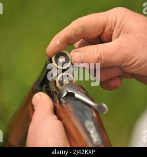 Mann lädt eine Schrotflinte Stockfoto