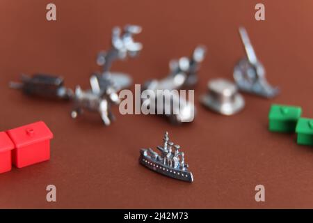 Monopoly Spiele Stücke mit 1 Schlachtschiff-Ikone Stück im Fokus und andere Symbole aus Fokus Stockfoto