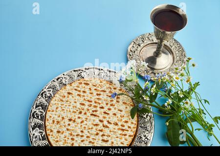Pesah-Feier-Konzept, jüdischer Passahfeiertag. Matza und roter Koscher. Traditionelles rituelles jüdisches Brot auf blauem Hintergrund Stockfoto