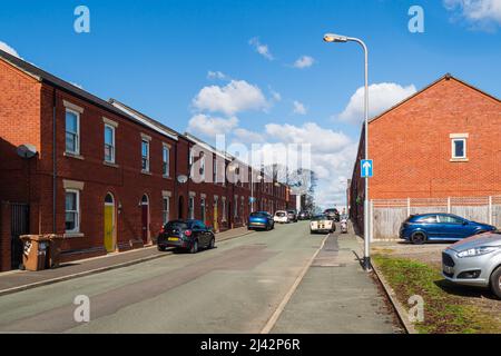 31.03.2022 St Helens, Merseyside, Großbritannien. Reihenhäuser teilen sich beide Seitenwände mit Nachbargrundstücken und bilden eine Reihe von Häusern, die sich entlang einer Straße erstrecken Stockfoto