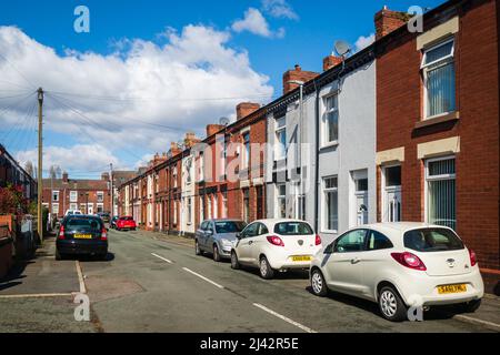 31.03.2022 St Helens, Merseyside, Großbritannien. Reihenhäuser teilen sich beide Seitenwände mit Nachbargrundstücken und bilden eine Reihe von Häusern, die sich entlang einer Straße erstrecken Stockfoto