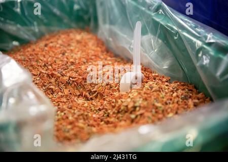 Nahaufnahme von getrockneten Flocken in einem Spülbehälter mit Schaufel Stockfoto