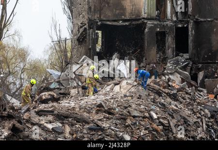 BORODYANKA, UKRAINE - 10. April 2022: Rettungskräfte arbeiten weiter daran, die Trümmer eines zerstörten Wohnblocks auszugraben und zu entfernen, der angeblich eine nicht näher bezeichnete Anzahl von Zivilisten unter sich begraben hat.Quelle: Mykhailo Palinchak/Alamy Live News Stockfoto