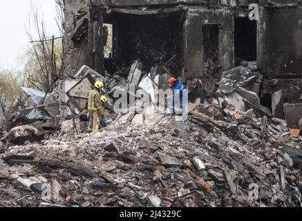 BORODYANKA, UKRAINE - 10. April 2022: Rettungskräfte arbeiten weiter daran, die Trümmer eines zerstörten Wohnblocks auszugraben und zu entfernen, der angeblich eine nicht näher bezeichnete Anzahl von Zivilisten unter sich begraben hat.Quelle: Mykhailo Palinchak/Alamy Live News Stockfoto