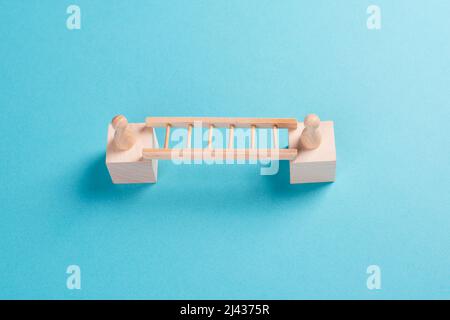 Zwei Menschen verbinden sich über eine Leiter, bauen eine Brücke zwischen Männern, Trennung und Verbindungskonzept, treffen sich, um Grenzen zu überwinden Stockfoto