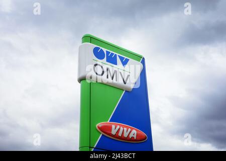 Prag, Tschechische Republik, Tschechien - 7. April 2022: OMV-Tankstelle. Werbemast mit Markenlogo. Wolkiger Himmel und Kopierbereich. Stockfoto