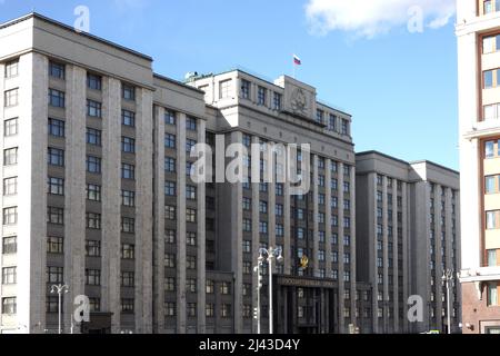 Das Gebäude der russischen Staatsduma mit der Aufschrift Staatsduma in russischer Sprache an der Fassade auf der Straße Okhotny Ryad in Moskau an einem sonnigen Tag Stockfoto
