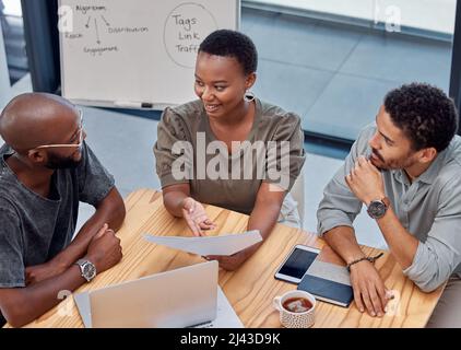 Reden wir über Geschäfte. Aufnahme einer Gruppe junger Geschäftsleute, die im Büro ein Gespräch führen. Stockfoto