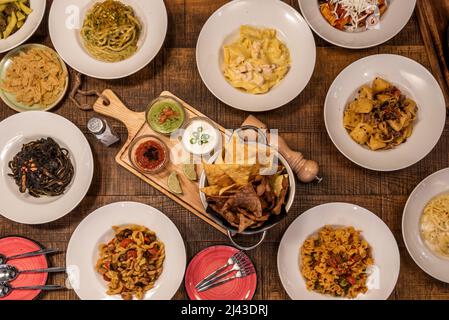 Set von italienischen Gerichten mit Parmigiana melanzane, Pasta aller Art, mit Pesto, mit Bolognese-Sauce, mit schwarzer Sauce und Meeresfrüchten und mehr Stockfoto