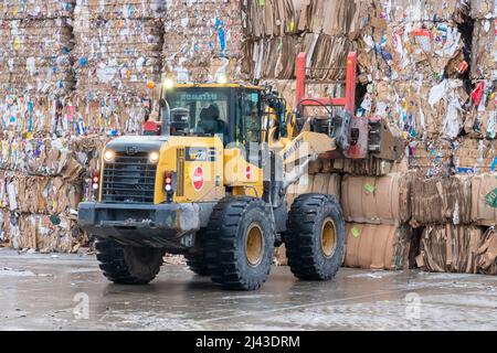 Schwere Maschinen, die in einer industriellen Recyclinganlage mit Recyclingpapier arbeiten. Stockfoto