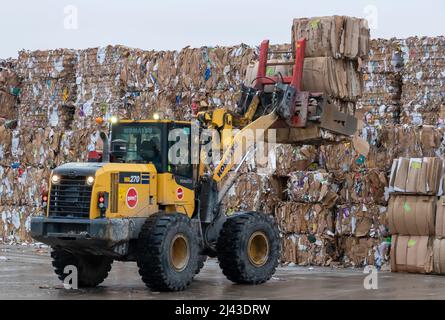 Schwere Maschinen, die in einer industriellen Recyclinganlage mit Recyclingpapier arbeiten. Stockfoto