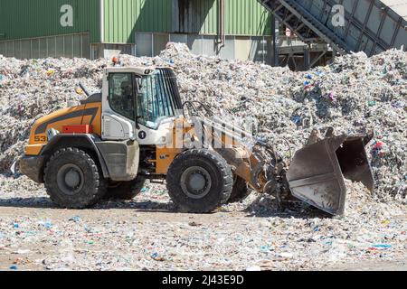 Schwere Maschinen, die in einer industriellen Recyclinganlage mit Recyclingpapier arbeiten. Stockfoto