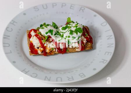 Dekoratives offenes köstliches Sandwich. Hausgemachtes Weizenbrot mit Dinkelmehl mit Käse, Mushrum, Sauerrahm, Ketchup, Petersilie. Stockfoto