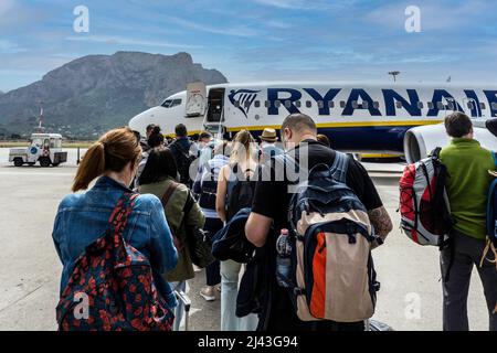 Menschen, die Schlange stehen, um an Bord eines Ryanair-Fluges zu gehen. Stockfoto