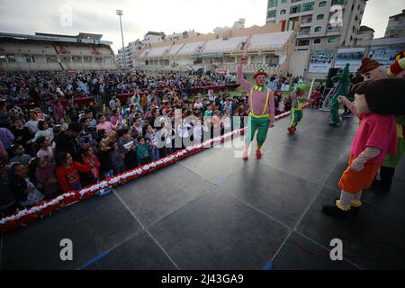 Gaza, Palästina. 11. April 2022. Clowns präsentieren eine Unterhaltungsshow für verwaiste Kinder in Gaza City anlässlich des „Arabischen Orphan-Tages“. Kredit: SOPA Images Limited/Alamy Live Nachrichten Stockfoto