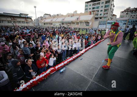 Gaza, Palästina. 11. April 2022. A Clowns präsentiert eine Unterhaltungsshow für verwaiste Kinder in Gaza City anlässlich des „Arabischen Orphan-Tages“. (Foto von Yousef Masoud/SOPA Images/Sipa USA) Quelle: SIPA USA/Alamy Live News Stockfoto