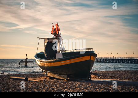 Schöner Morgenblick an der polnischen Küste in Gdynia. Schiff auf einem Sandstrand am Morgen. Stockfoto