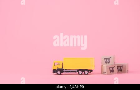 Logistik und Lieferservice - LKW und Papierkartons oder Paket mit einem Warenkorb-Logo auf rosa Hintergrund. Shopping-Service auf der Online Stockfoto