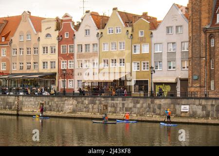 Danzig Polen März 2022 Gruppe von Sup-Surfern stehen auf Paddle-Board, Frauen stehen auf Paddeln zusammen in der Stadt Motlawa Fluss und Kanal in der Altstadt Danzig Polen. Tourismusattraktion Aktive Erholung im Freien Soziale Distanzierung Reiseziele Stockfoto