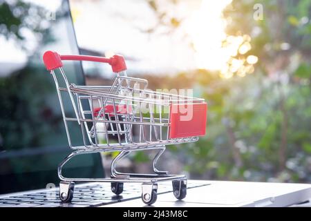 Online einkaufen - Warenkorb oder Trolley auf einer Laptop-Tastatur. Shopping-Service im Online-Web. Stockfoto