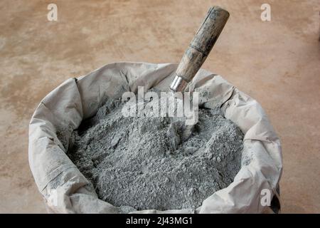 Zementpulver und Kelle in Beutelpackung gelegt Stockfoto