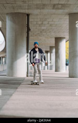 Skateboarding Junge in der Stadt . Stadtarchitektur. Skate Spot. Vertikales Foto Stockfoto