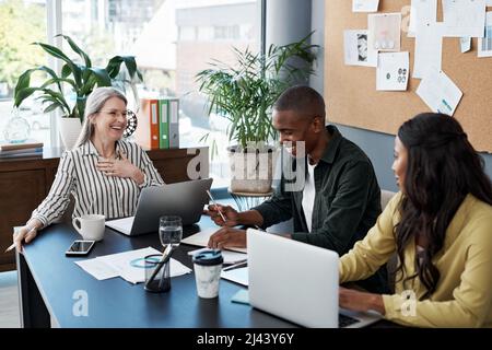 Wie ein Dieb braucht es Zeit, um so groß zu sein. Aufnahme einer Gruppe von Geschäftsleuten, die in einem modernen Büro ein Brainstorming und einen Laptop verwendeten. Stockfoto