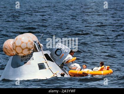 Die Hauptmannschaft der ersten bemannten Apollo-Mission, die am Wasseraustraining im Golf von Mexiko teilnahm. Von links nach rechts befinden sich die Astronauten Walter Schirra (der ins Rettungsinsel tritt), Donn Eisele und Walter Cunningham. Stockfoto