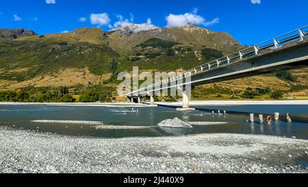 Die Hauptstraße zwischen Glenorchy und Lake Sylvan überquert eine Straßenbrücke über den atemberaubenden Fluss in der Natur Stockfoto