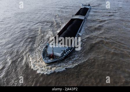 Köln, Deutschland. 11. April 2022. Ein mit Steinkohle beladenes Frachtschiff segelt auf dem Rhein. Angetrieben durch die hohen Energiepreise stieg die Inflation in Deutschland im März erstmals seit der Wiedervereinigung 1990 über die Marke von sieben Prozent. Nach vorläufigen Angaben des Statistischen Bundesamtes lagen die Verbraucherpreise um 7,3 Prozent über dem Vorjahresmonat. Details will die Wiesbadener Behörde am 12. April bekannt geben. Quelle: Rolf Vennenbernd/dpa/Alamy Live News Stockfoto