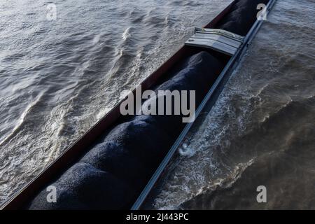 Köln, Deutschland. 11. April 2022. Ein mit Steinkohle beladenes Frachtschiff segelt auf dem Rhein. Angetrieben durch die hohen Energiepreise stieg die Inflation in Deutschland im März erstmals seit der Wiedervereinigung 1990 über die Marke von sieben Prozent. Nach vorläufigen Angaben des Statistischen Bundesamtes lagen die Verbraucherpreise um 7,3 Prozent über dem Vorjahresmonat. Details will die Wiesbadener Behörde am 12. April bekannt geben. Quelle: Rolf Vennenbernd/dpa/Alamy Live News Stockfoto