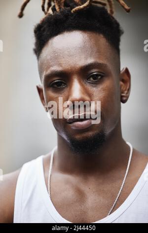 Ich Laufe diese Straßen. Ein Porträt eines hübschen jungen Gangsters, der draußen auf der Straße steht. Stockfoto