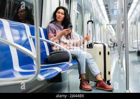 Frau, die in einem U-Bahn-Auto telefoniert Stockfoto