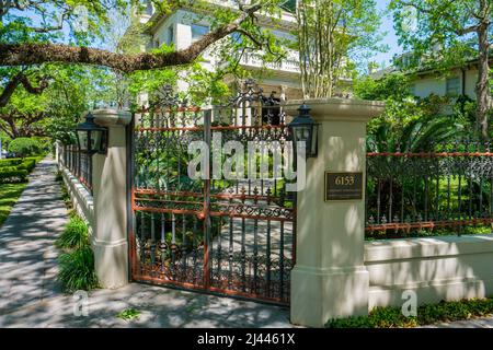 NEW ORLEANS, LA, USA - 8. APRIL 2022: Eingangstor und „ständige Überwachung“-Plakette am Eingang des Herrenhauses in der St. Charles Avenue 6153 Stockfoto