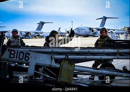 US Air Force Airmen vom 305. Air Mobility Wing mit Mission-orientierter Schutzausrüstung bereiten sich darauf vor, Wartungsgeräte auf einen C-17 Globemaster III hochzuladen, was die Fähigkeit demonstriert, in einer umkämpften Umgebung während einer Bereitschaftsübung auf der Joint Base McGuire-Dix-Lakehurst, New Jersey, 4. April 2022, zu überleben und zu operieren. Trainingsübungen stärken die Bereitschaft von Airmen und stärken bewusst die Kampfkultur des Air Mobility Command, um eine konkurrenzlose schnelle globale Mobilität zu bieten, die in der Lage ist, die Joint Force zu schützen und zu erhalten. Stockfoto