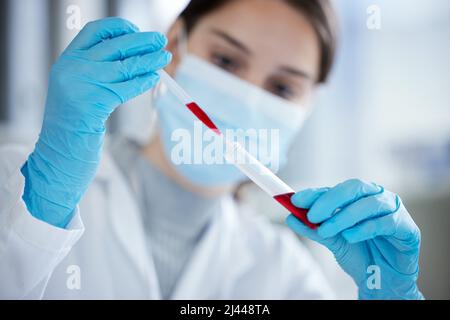 Durchführung mehrerer Tests zur Bestätigung der Ergebnisse. Nahaufnahme einer jungen Frau, die in einem Labor mit einer Pipette und einem Reagenzglas gearbeitet hat. Stockfoto