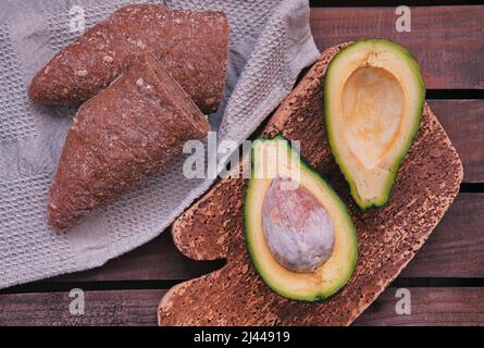 Oben Aufnahme von Avocado und Brot vor Holzhintergrund Stockfoto