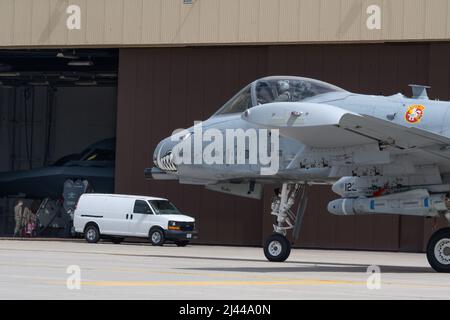 Ein A-10 Thunderbolt taxiert während der Übung Agile Tiger auf der Whiteman Air Force Base, Missouri, am 5. April 2022 an einem B-2 Spirit vorbei. Übung Agile Tiger gibt uns die Möglichkeit, operative Unberechenbarkeit zu üben und gleichzeitig unseren Partnern und Alliierten zu versichern, dass wir bereit sind, jederzeit und überall Atomoperationen und globale Streiks durchzuführen. (USA Luftwaffe Foto von Airman 1. Klasse Bryson Britt) Stockfoto