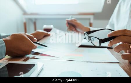 Die Kollegen betonen, dass sie über den Bericht über die Finanzergebnisse sprechen und mit den Finanzinformationen über die Papierkram mit einer Analyse über planni verglichen werden Stockfoto