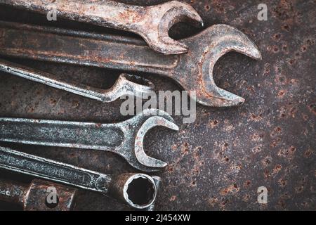 Sammlung von alten Schraubenschlüsseln auf einem rostigen Metalltisch. Draufsicht Stockfoto