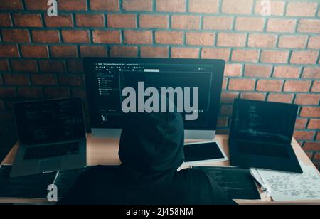 Hacker in der Haube arbeiten mit Computer mit Hacking brechen in Datenserver. Stockfoto