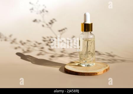 Naturölkosmetik auf Holzsockel. Leere Tropfferglas Flasche Mock-up. Ölige kosmetische Pipette. Spa-Konzept. Mineralisches Bio-Öl. Beauty-Produkte Stockfoto