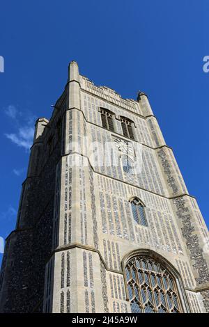 Westturm der Pfarrkirche St. Peter und St. Paul in Suffolk und blauer Himmel mit weißer Wolke im Hintergrund. Stockfoto