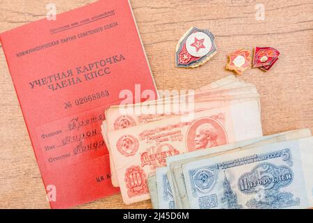 Buch über die Mitgliedschaft der Kommunistischen Partei Sowjetunion/Russland, Pinnschilder (siehe BANKNOTEN) und 1961 russische Banknoten mit 5 und 10 Rubel (auch Rubel). Stockfoto